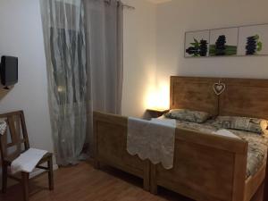 sypialnia z łóżkiem, krzesłem i oknem w obiekcie B&B Rosso Pila w Trydencie
