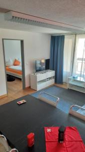 a living room with a room with a bed and a table at Davos - Cozy Escape - Mountain Rentals in Davos