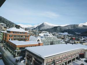 a city with snow on the roofs of buildings at Davos - Cozy Escape - Mountain Rentals in Davos