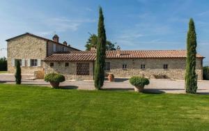 a large stone building with trees in front of it at Villa Lotus Magliano in Magliano in Toscana