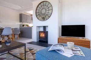 a living room with a tv and a fireplace at Sandpipers, Port Isaac Bay Holidays in Port Isaac
