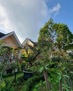a garden with trees and plants in front of a house at Villa Kota Bunga AA2-11 in Cikundul