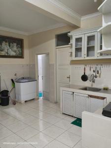 a kitchen with white cabinets and a tile floor at Villa Kota Bunga AA2-11 in Cikundul