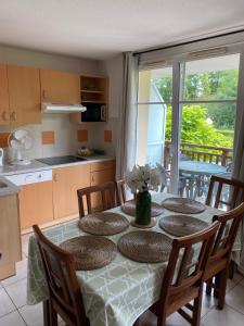 een keuken met een tafel met stoelen en een eetkamer bij Vue Sur Green in Levernois