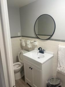 a bathroom with a sink and a toilet and a mirror at The Hermitage Inn and Taphouse in Petersburg