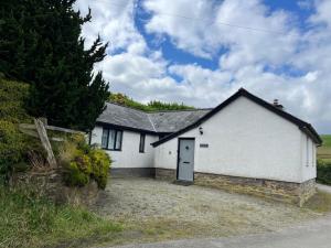 a white house with a door in a driveway at Hebron Rural converted chapel in Nantglyn
