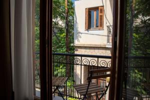 ein Balkon mit einer Bank mit Blick auf ein Gebäude in der Unterkunft Senses Aegina Downtown Residence in Ägina Stadt