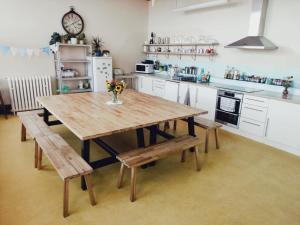a kitchen with a wooden table and benches in it at Murray Library Hostel in Anstruther