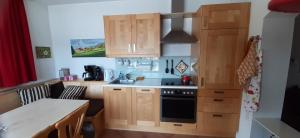 a kitchen with wooden cabinets and a stove top oven at Bergzicht in Mariapfarr