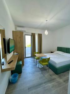 een hotelkamer met een bed en een bureau met een computer bij River Residence in Orikum