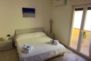 a bedroom with a bed with two shoes on it at Marida - Dimora moderna in centro storico in SantʼAntìoco