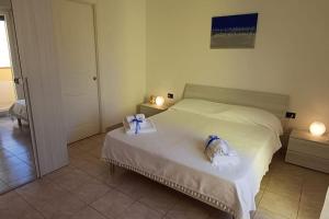 a bedroom with a bed with two towels on it at Marida - Dimora moderna in centro storico in SantʼAntìoco +8 photos