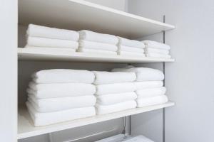 une pile de serviettes sur une étagère dans un placard dans l'établissement Mova Villa Koshi Misawa north, à Yuge 23 autres photos
