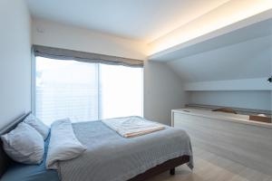 une chambre avec un lit et une grande fenêtre dans l'établissement Mova Villa Koshi Misawa north, à Yuge