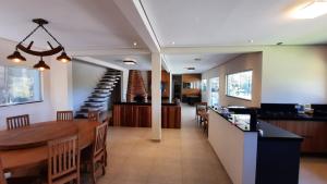 comedor y sala de estar con mesa de comedor y escalera en Recanto Ibiunature Clube, en Ibiúna