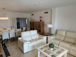 a living room with white furniture and a table at Alhaurín Golf Premium Views in Alhaurín el Grande