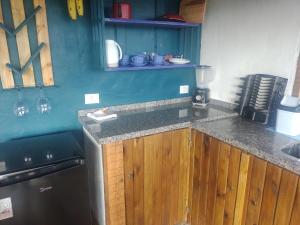 a kitchen with wooden cabinets and a counter top at Na'raucária in Cambará