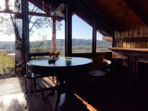 a table in a room with a large window at Na'raucária in Cambará