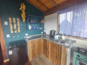 a kitchen with wooden cabinets and a counter top at Na'raucária in Cambará