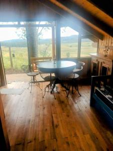 a table and chairs in a room with a large window at Na'raucária in Cambará