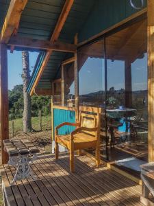 a porch of a house with a bench and a table at Na'raucária in Cambará