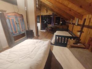 a bedroom with two beds in a room with wooden walls at Na'raucária in Cambará
