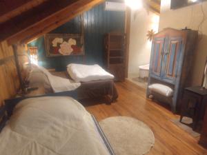 a room with two beds and a chair in a room at Na'raucária in Cambará