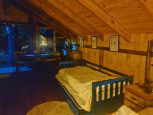 a bedroom with a bed in a wooden cabin at Na'raucária in Cambará