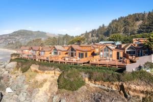 a house on a cliff next to the ocean at Ocean Front Cabin 16, Jacuzzi & Incredible Views in Smith River