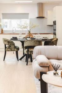 a living room with a table and chairs and a kitchen at Newly refurbished cosy 2 bed in Wembley in London