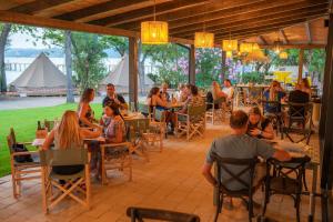 a group of people sitting at tables in a restaurant at Trasimeno Glamping Resort in Magione
