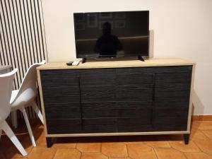Un televisor encima de una cómoda en una habitación. en FRONTE MARE apartment, en Barcellona-Pozzo di Gotto 9 fotos más