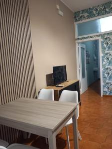 un comedor con una mesa y un ordenador en un escritorio en FRONTE MARE apartment, en Barcellona-Pozzo di Gotto