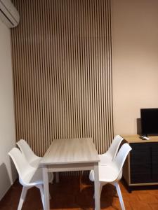 una mesa y sillas frente a una pared en FRONTE MARE apartment, en Barcellona-Pozzo di Gotto