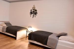 a bedroom with two beds and a tree on the wall at PENZION u Restaurace Na Koreji in Štětí
