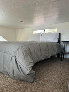 a bed with a blanket on it in a bedroom at Oceanview Cabin 20 Private Jacuzzi Pet Friendly in Smith River