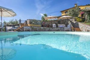 a large swimming pool with a house in the background at Villa Sole Di Toscana in Cantagrillo