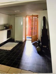 a room with a kitchen with a door and a stove at Sentrumsnær kjellerleilighet, nær sykehus og høgskole, parkering in Haugesund +2 photos