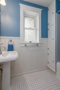 a bathroom with a white sink and a window at The Big House in Jefferson City