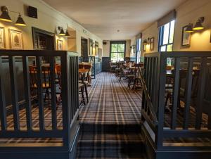 a hallway with tables and chairs in a restaurant at The Buck Hotel in Great Ayton