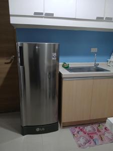 a kitchen with a stainless steel refrigerator next to a sink at Centro Tower - 2 Bedroom Fully Furnished in Manila +27 photos