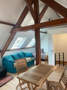 a living room with a blue couch and a table at Maison du Cap Lihou, Duplex au 1er et 2ème étage mansardé, Quartier Historique, GRANVILLE in Granville