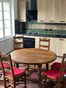 a kitchen with a wooden table and four chairs at Maison du Cap Lihou, Duplex au 1er et 2ème étage mansardé, Quartier Historique, GRANVILLE in Granville