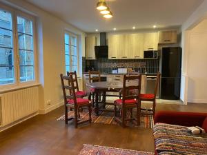 a living room with a table and chairs and a kitchen at Maison du Cap Lihou, Duplex au 1er et 2ème étage mansardé, Quartier Historique, GRANVILLE in Granville +47 photos