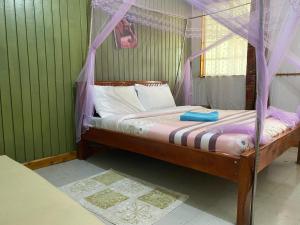 a bedroom with a bed with a canopy at My Lily Cottage Naivasha in Naivasha