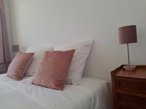 a bed with two pillows and a lamp on a night stand at Evasions-Dérobade, centre-ville, gare in Auterive
