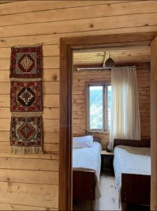 a bedroom with two beds in a log cabin at Guest House Mokvare in Gundauri