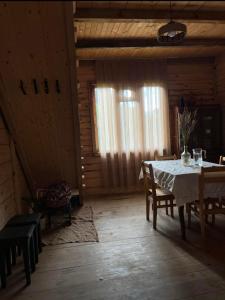 a dining room with a table and chairs in a cabin at Guest House Mokvare in Gundauri +29 photos