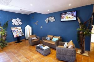 - un salon avec des canapés et une télévision murale dans l'établissement Village Vacances de Ramatuelle - Le Sentier des Pins, à Saint-Tropez