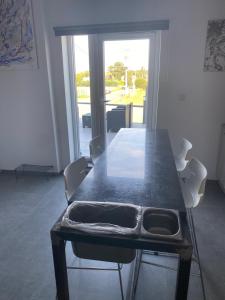 a table and chairs in a room with a large window at Résidence Basilic in Grâce-Hollogne +3 photos